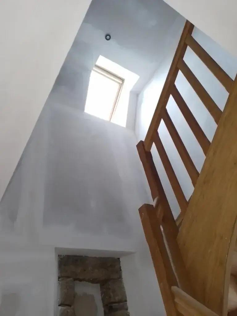 agencement intérieur : pose de placo et bandes dans une cage d'escalier tout hauteur