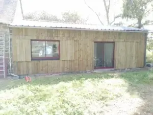 agencement extérieur : Pose d'une fenêtre et d'une port-fenêtre en aluminium rouge bordeau RAL7016 sur une extension de maison en ossature bois