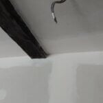 agencement intérieur : gros plan sur pose placo mur et plafond possédant des poutres en bois apparentes