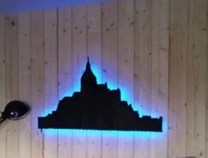 ébénisterie : à fixer au mur, silhouette du Mont Saint-Michel peinte en noir et rétro-éclairée par néon bleu