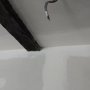 agencement intérieur : gros plan sur pose placo mur et plafond possédant des poutres en bois apparentes